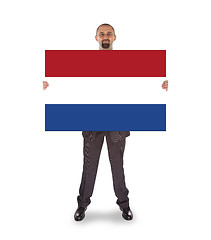 Image showing Smiling businessman holding a big card, flag of the Netherlands