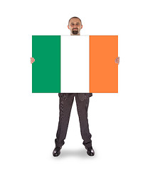 Image showing Smiling businessman holding a big card, flag of Ireland