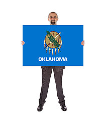 Image showing Smiling businessman holding a big card, flag of Oklahoma
