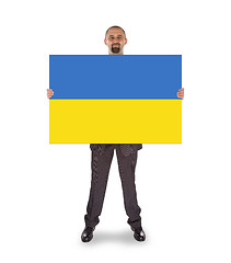Image showing Smiling businessman holding a big card, flag of Ukraine