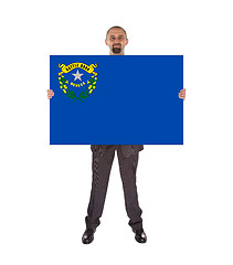 Image showing Smiling businessman holding a big card, flag of Nevada