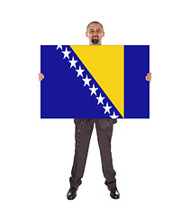 Image showing Smiling businessman holding a big card, flag of Bosnia and Herze