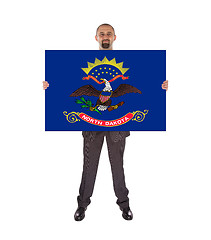 Image showing Smiling businessman holding a big card, flag of North Dakota