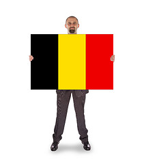 Image showing Smiling businessman holding a big card, flag of Belgium