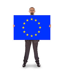 Image showing Smiling businessman holding a big card, flag of the European Uni