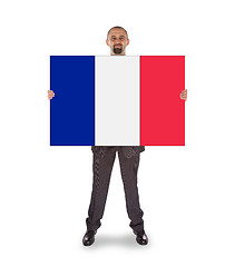 Image showing Smiling businessman holding a big card, flag of France