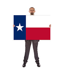 Image showing Smiling businessman holding a big card, flag of Texas