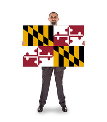 Image showing Smiling businessman holding a big card, flag of Maryland