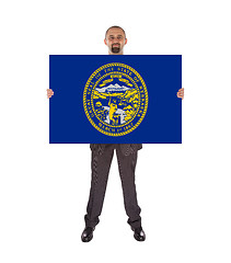 Image showing Smiling businessman holding a big card, flag of Nebraska
