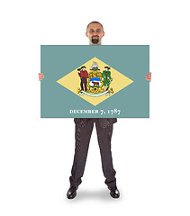 Image showing Smiling businessman holding a big card, flag of Delaware