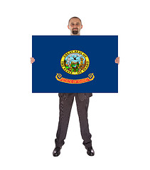 Image showing Smiling businessman holding a big card, flag of Idaho