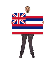 Image showing Smiling businessman holding a big card, flag of Hawaii