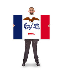 Image showing Smiling businessman holding a big card, flag of Iowa