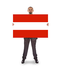 Image showing Smiling businessman holding a big card, flag of Austria