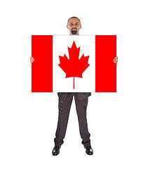 Image showing Smiling businessman holding a big card, flag of Canada
