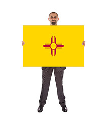 Image showing Smiling businessman holding a big card, flag of New Mexico