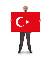 Image showing Smiling businessman holding a big card, flag of Turey