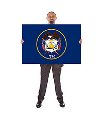 Image showing Smiling businessman holding a big card, flag of Utah