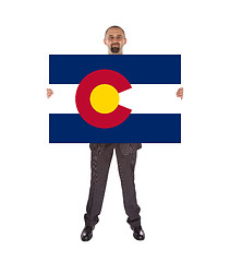 Image showing Smiling businessman holding a big card, flag of Colorado