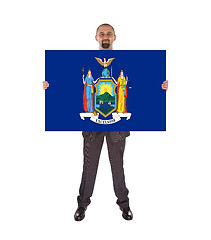 Image showing Smiling businessman holding a big card, flag of New York