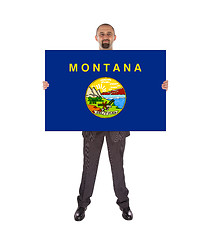 Image showing Smiling businessman holding a big card, flag of Montana