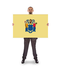 Image showing Smiling businessman holding a big card, flag of New Jersey