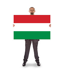 Image showing Smiling businessman holding a big card, flag of Hungary