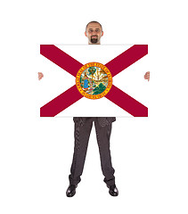 Image showing Smiling businessman holding a big card, flag of Florida