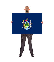 Image showing Smiling businessman holding a big card, flag of Maine