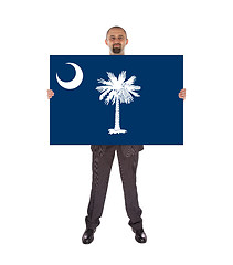 Image showing Smiling businessman holding a big card, flag of South Carolina