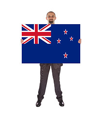 Image showing Smiling businessman holding a big card, flag of New Zealand