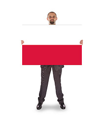 Image showing Smiling businessman holding a big card, flag of Poland