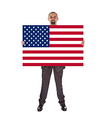 Image showing Smiling businessman holding a big card, flag of the United State