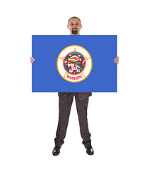 Image showing Smiling businessman holding a big card, flag of Minnesota