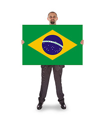 Image showing Smiling businessman holding a big card, flag of Brazil