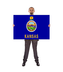 Image showing Smiling businessman holding a big card, flag of Kansas