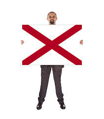 Image showing Smiling businessman holding a big card, flag of Alabama