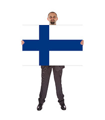 Image showing Smiling businessman holding a big card, flag of Finland