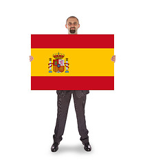 Image showing Smiling businessman holding a big card, flag of Spain