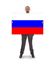 Image showing Smiling businessman holding a big card, flag of Russia