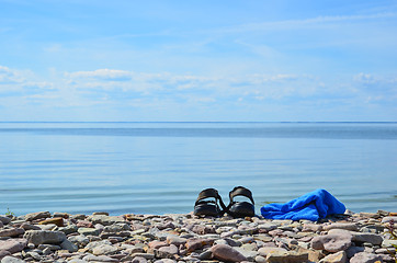 Image showing Shoes and towel at coast