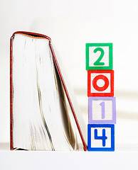 Image showing Alphabet block with 2014 besides book