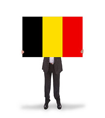 Image showing Smiling businessman holding a big card, flag of Belgium