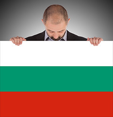 Image showing Smiling businessman holding a big card, flag of Bulgaria