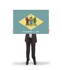 Image showing Smiling businessman holding a big card, flag of Delaware