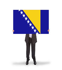 Image showing Smiling businessman holding a big card, flag of Bosnia and Herze