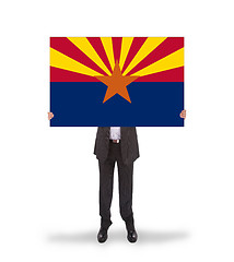 Image showing Smiling businessman holding a big card, flag of Arizona