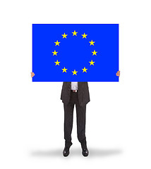 Image showing Smiling businessman holding a big card, flag of the European Uni