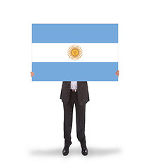 Image showing Smiling businessman holding a big card, flag of Argentine