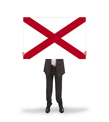 Image showing Smiling businessman holding a big card, flag of Alabama